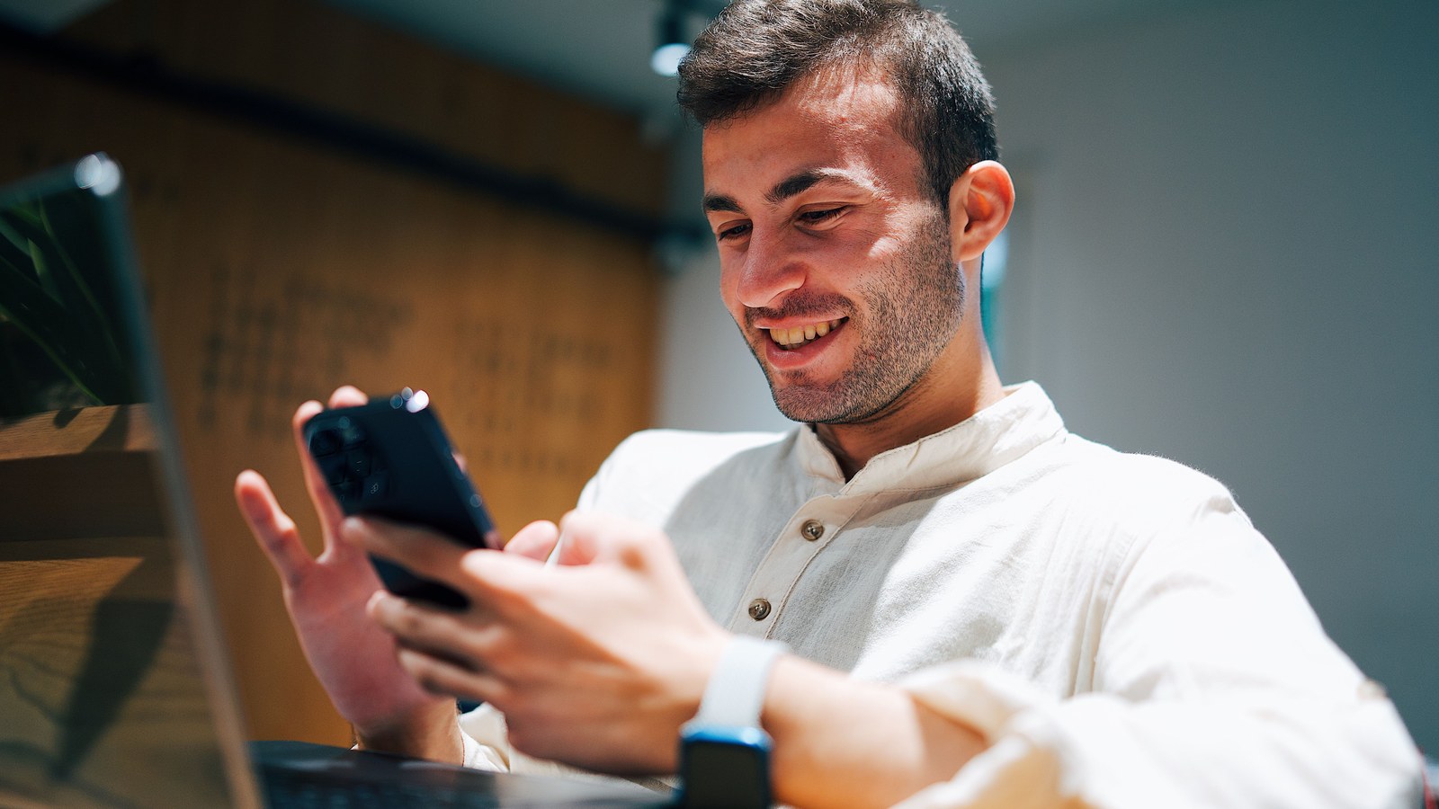 رجل يراجع الهاتف والكمبيوتر للتأكد من وصول الملفات بعد النقل